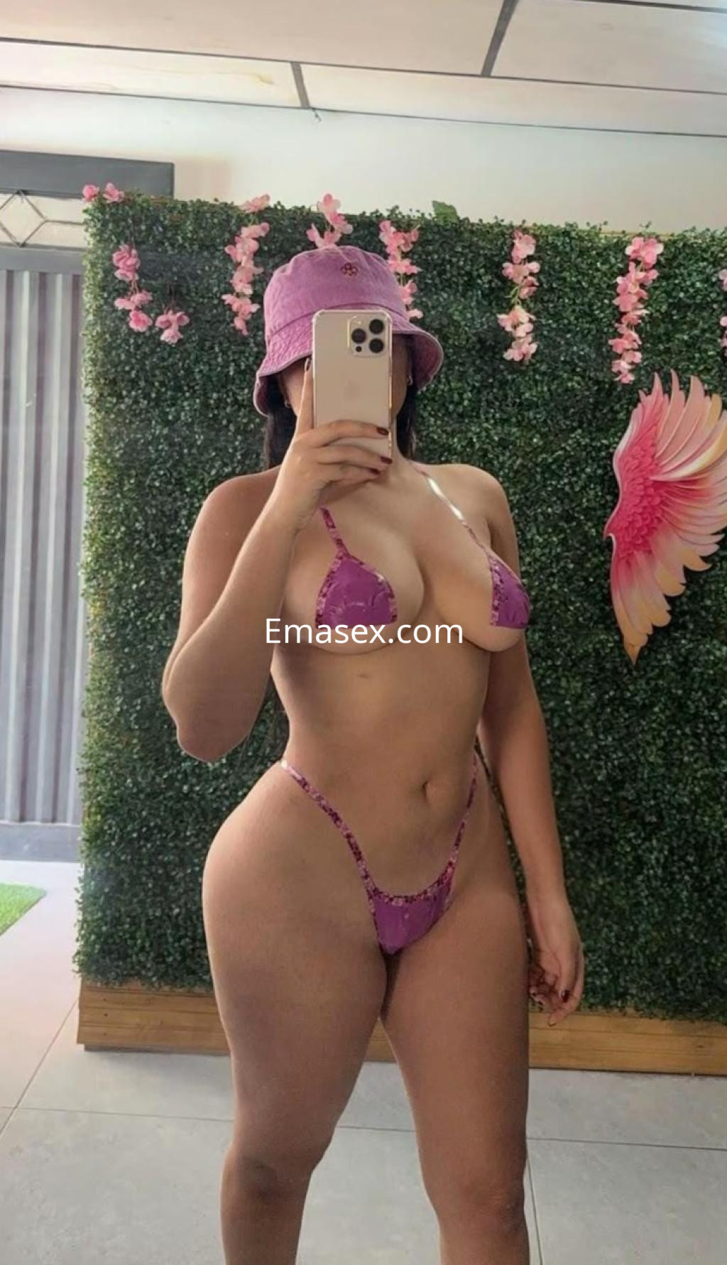 Puta en Santander, mostrando su figura en un bikini púrpura mientras se toma una selfie con un sombrero.