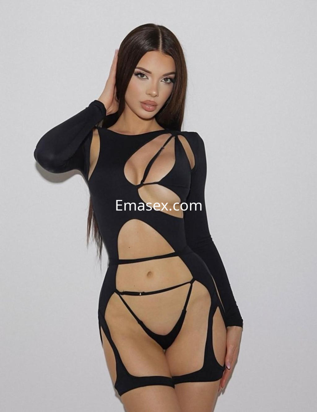 La escort en Salamanca viste un ajustado vestido negro con cortes estratégicos, mostrando su figura.