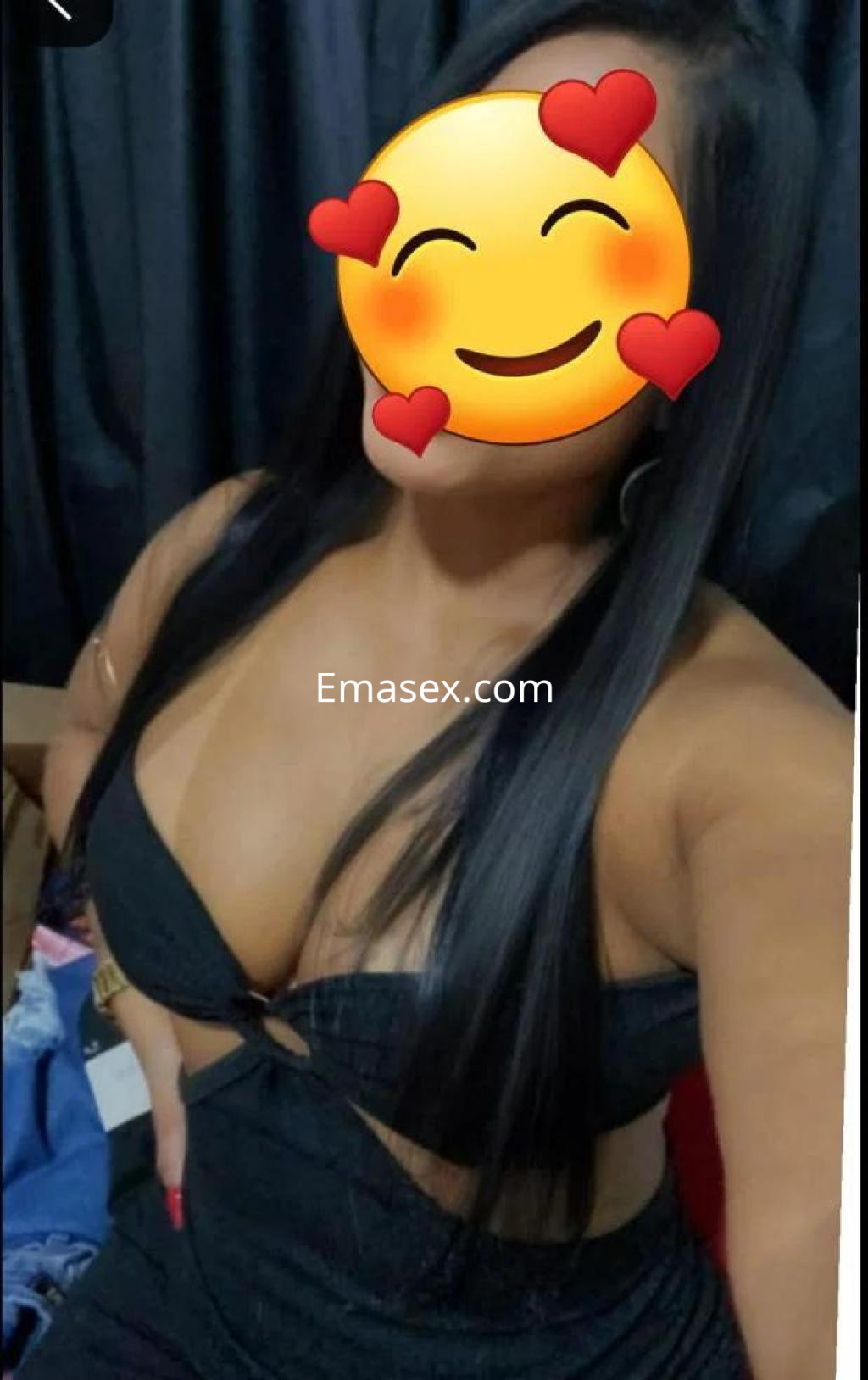 Puta con cabello largo y lacio, viste un top negro ajustado y posa sonriente en un ambiente oscuro en Toledo.