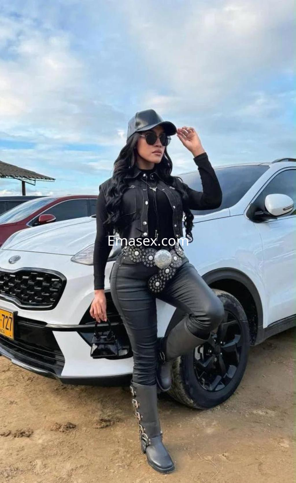 La puta posa con una chaqueta negra y pantalones de cuero junto a un coche en Pontevedra.