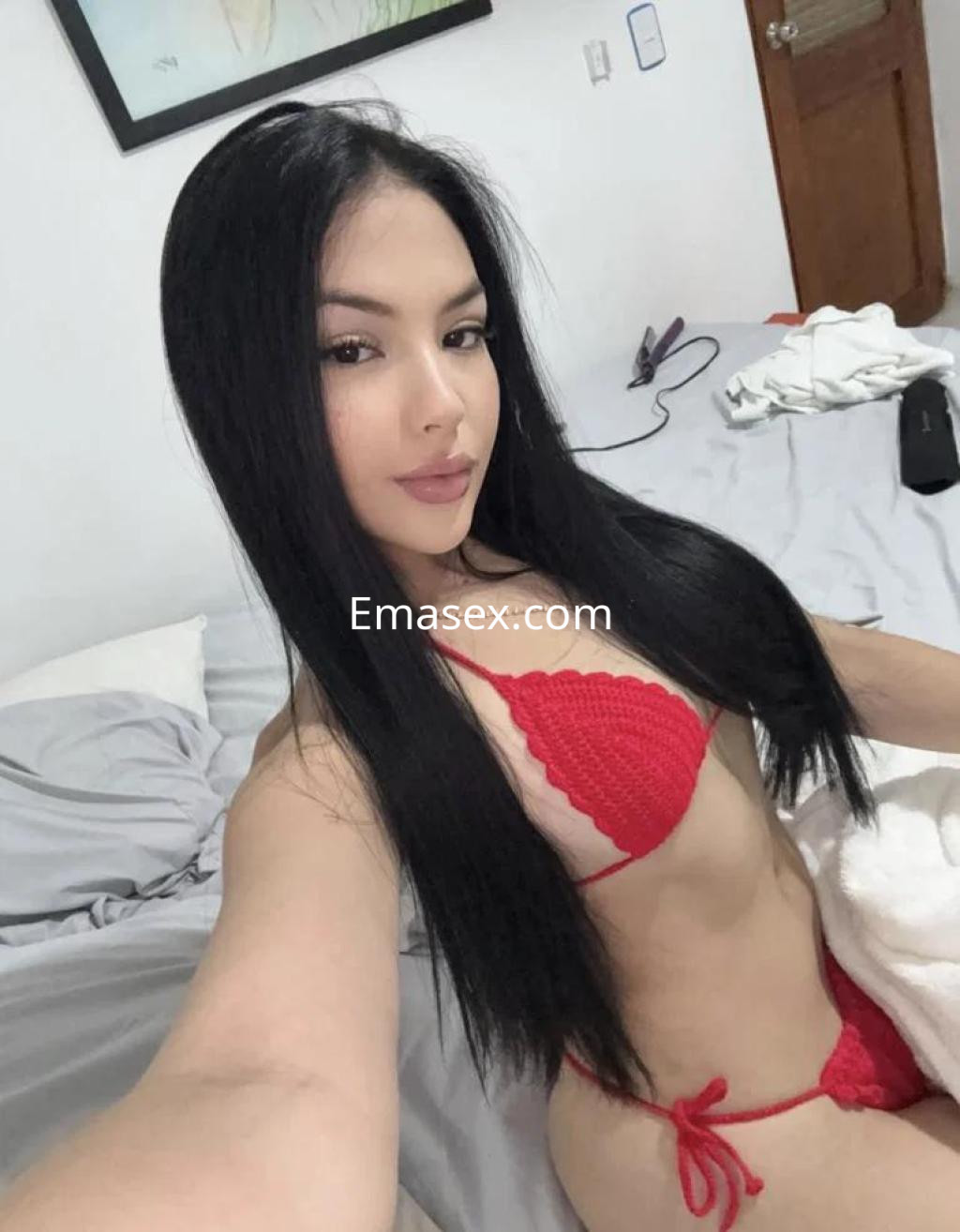 Escort en Tenerife posa en un entorno interior, luciendo un bikini rojo y con el cabello largo y lacio.
