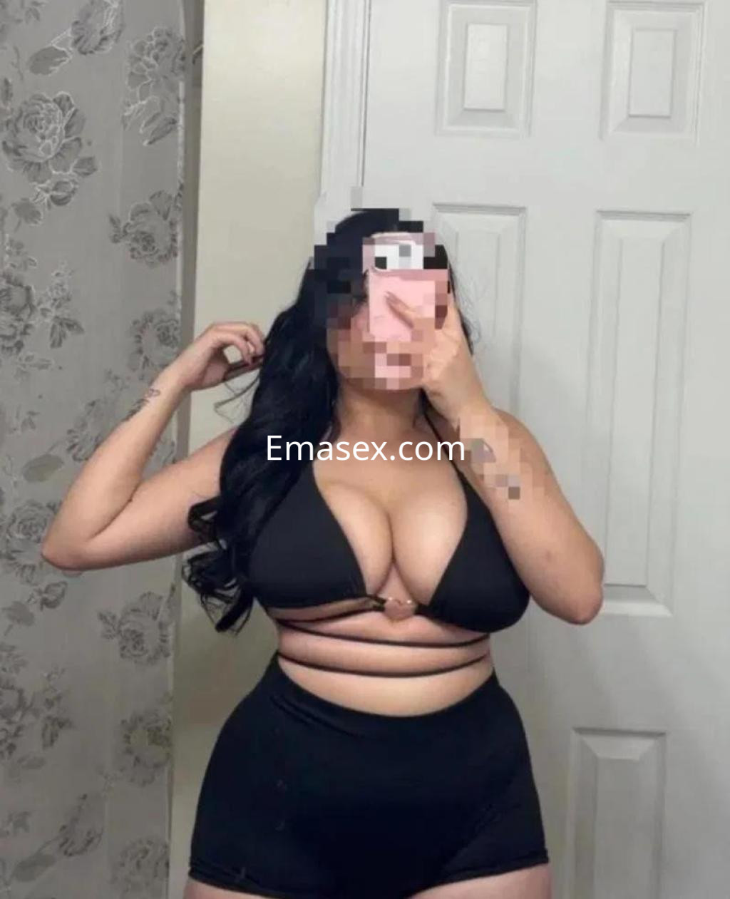 La puta en Huelva se muestra en un baño con un bikini negro que resalta su figura y cabello largo.