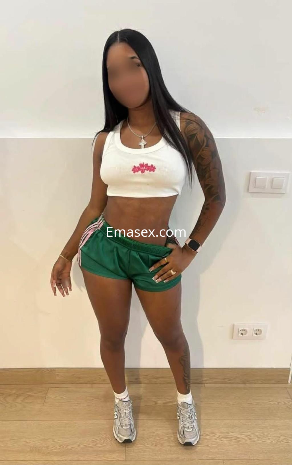 Escort en Barcelona con top blanco y pantalones cortos verdes, mostrando un entorno minimalista y moderno.