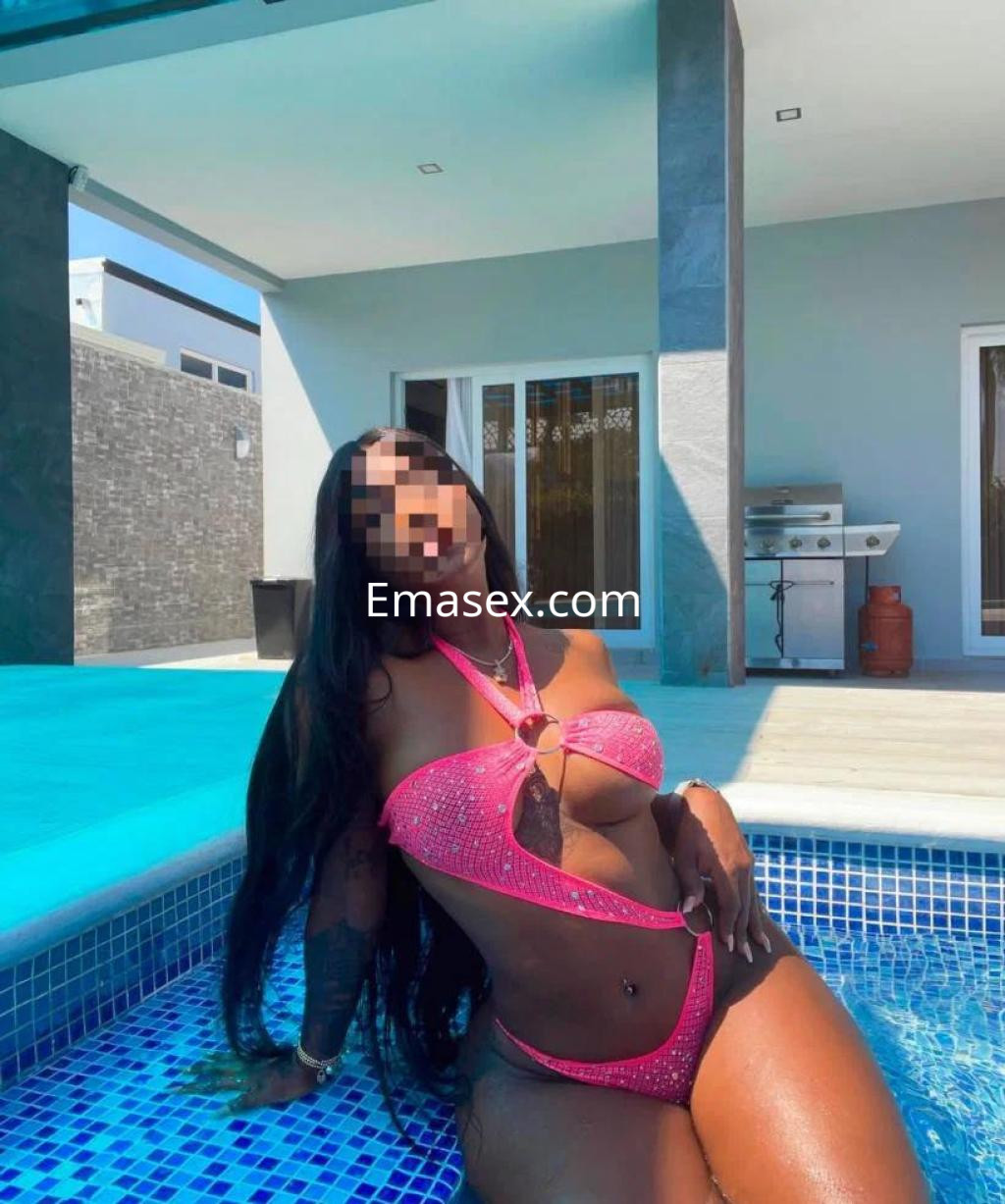 Puta en Cáceres posando en una piscina, con un bikini rosa brillante y cabello largo y lacio.