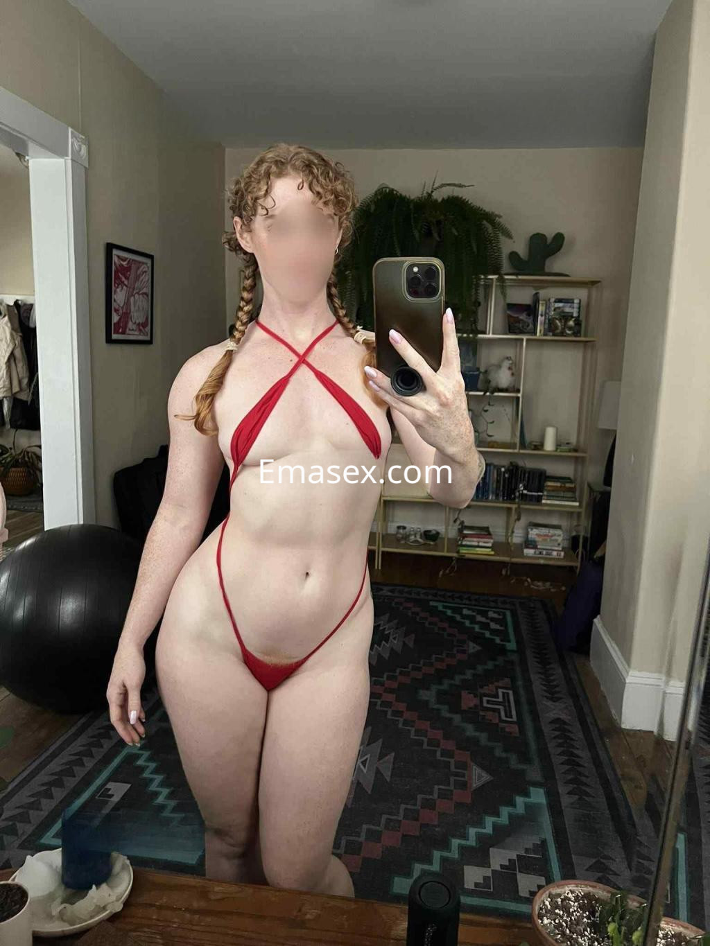 Puta en Madrid posa con un bikini rojo en un ambiente interior, mostrando su figura y cabello rizado.