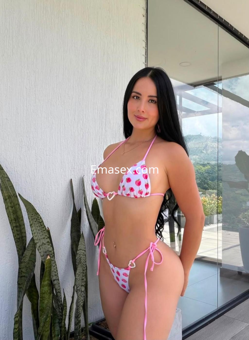 Puta en Donosti con cabello largo y lacio, viste un bikini blanco con estampado de fresas y se encuentra en un entorno moderno.