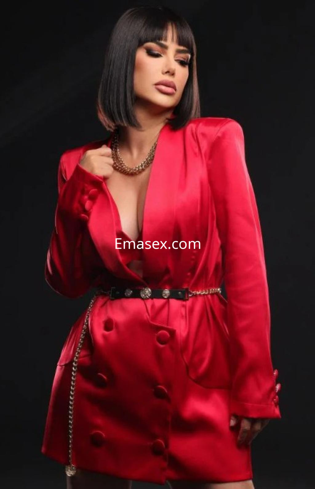 Escort en Coruña viste un chaquetón rojo brillante, con un escote pronunciado y un cinturón decorativo.