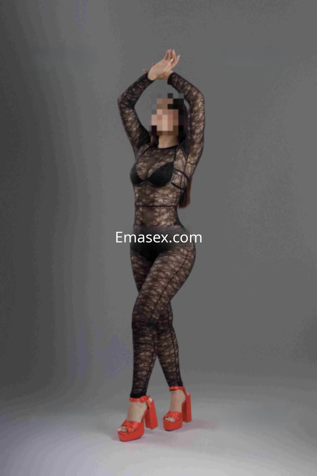 Escort en Murcia con un conjunto negro de malla que resalta su figura, complementado con tacones rojos.