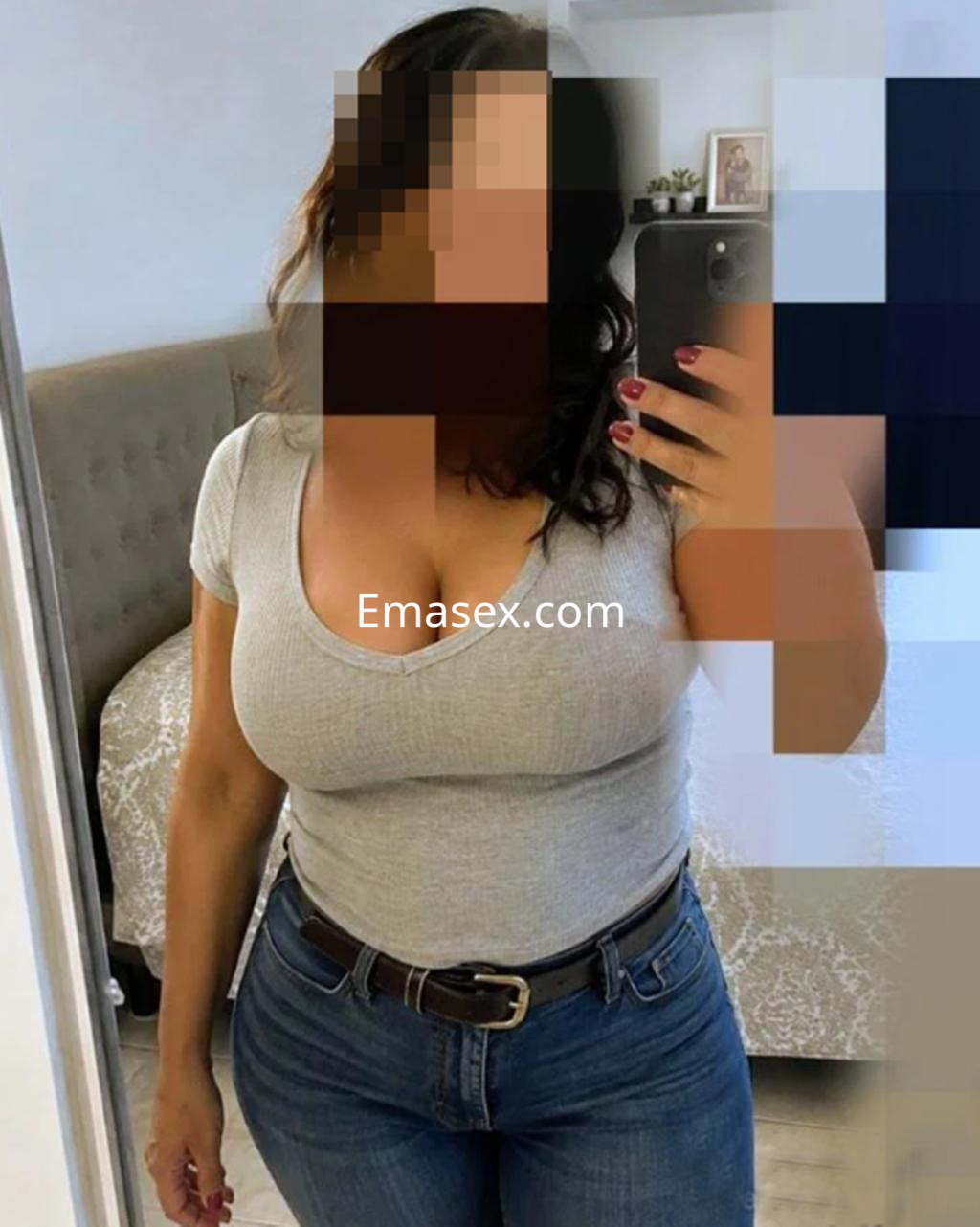 Puta en Logroño muestra una blusa gris ajustada y jeans, posando frente a un espejo.