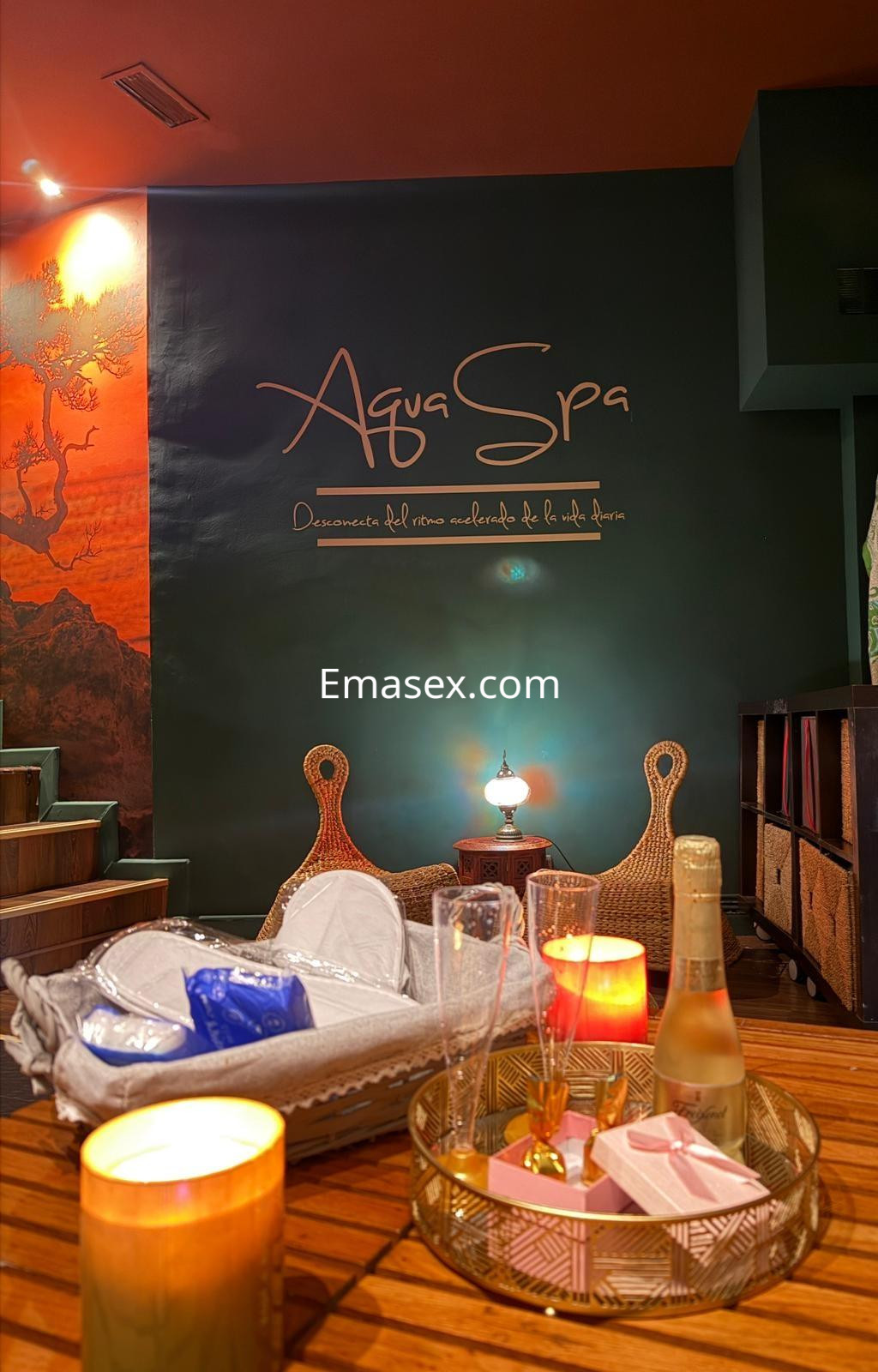 La imagen muestra un ambiente de spa en Madrid con decoración elegante, velas encendidas y una botella de champán.