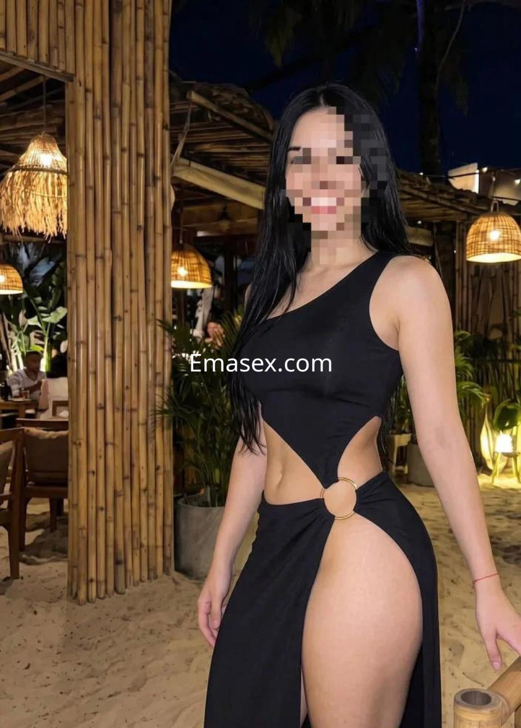 Puta con vestido negro de una sola manga y corte lateral, posando en un ambiente tropical en Las Palmas.