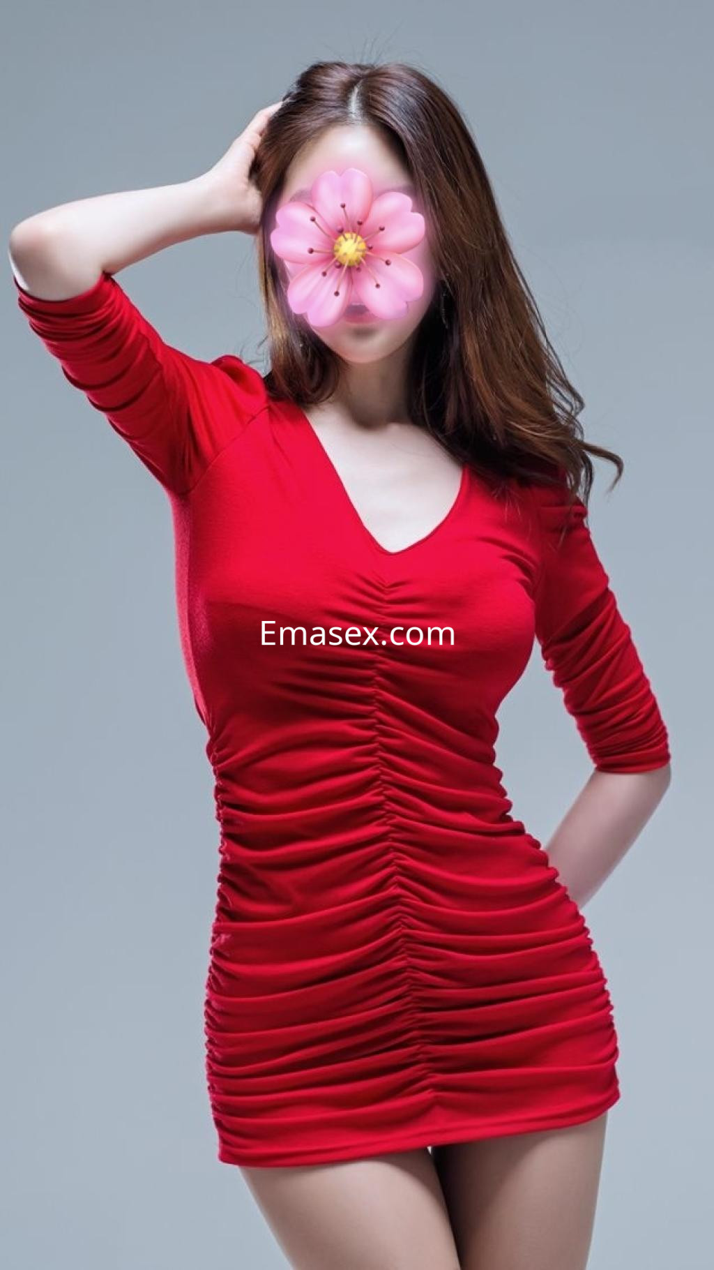 Escort en Gijón posando con un vestido rojo ajustado que resalta su figura y un fondo neutro.
