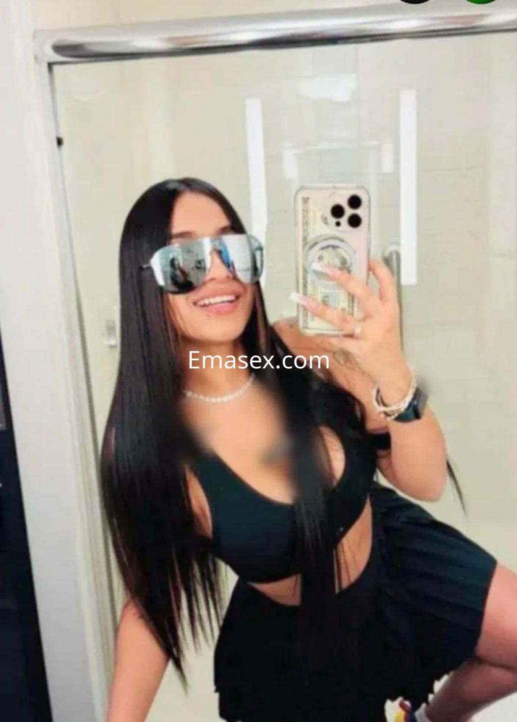 La puta luce un top negro y una falda corta en un baño, con gafas de sol y cabello largo y lacio en Albacete.