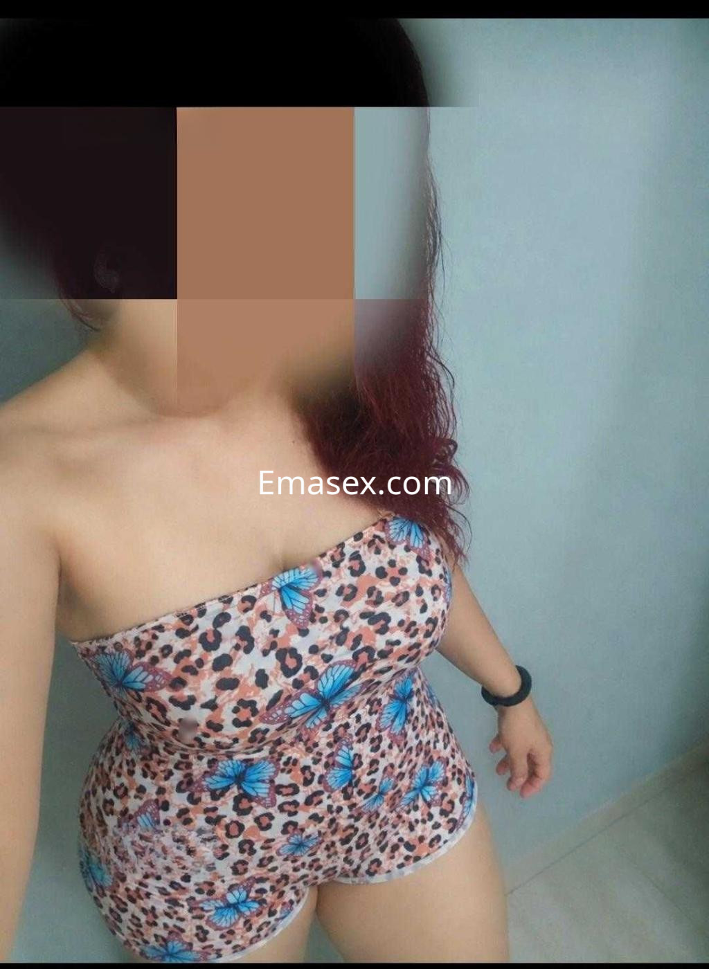 Puta en Madrid con un body ajustado de estampado de leopardo y mariposas, posando de manera seductora.