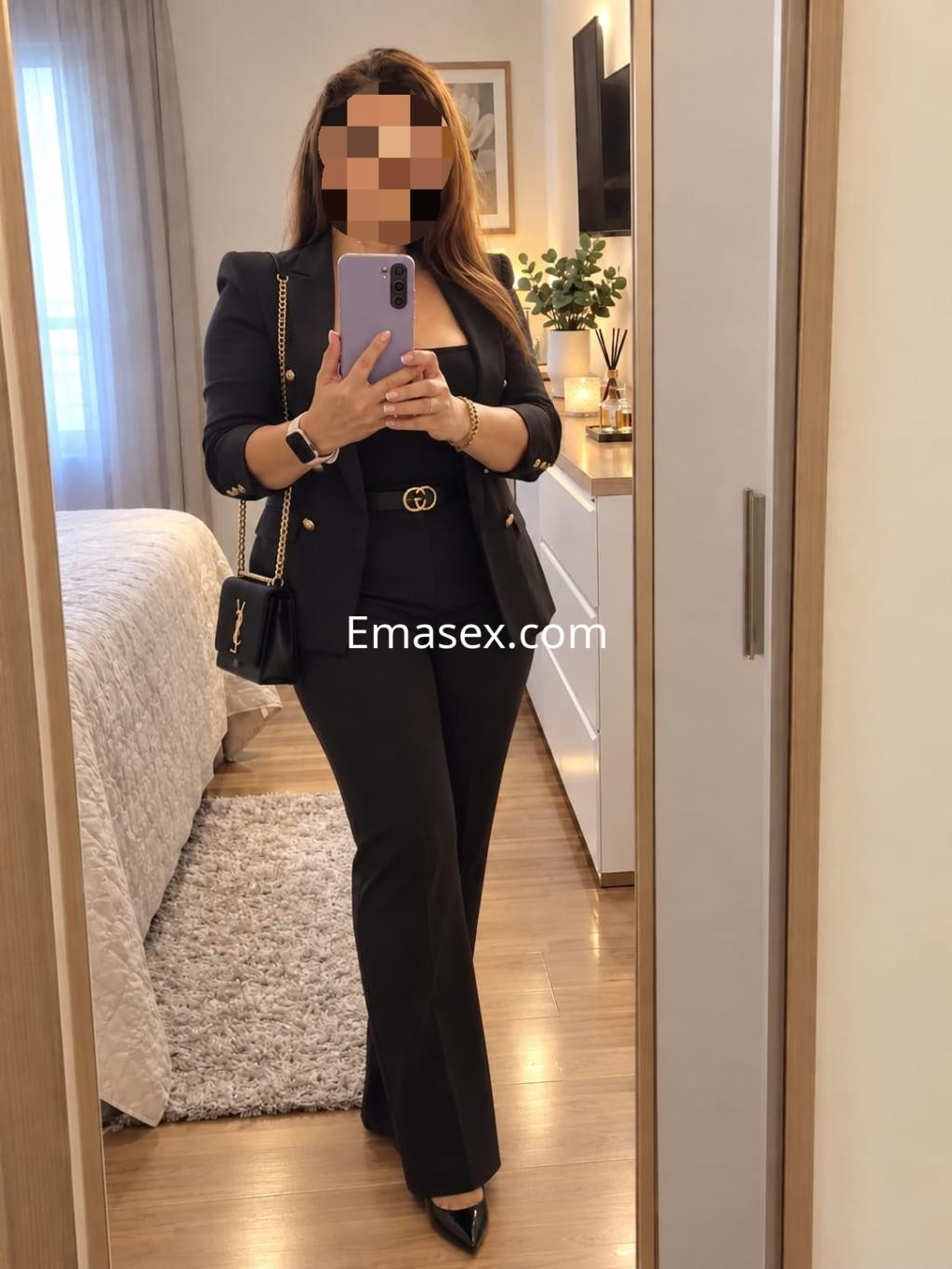 La puta posa frente al espejo en Valladolid, vistiendo un traje negro elegante y tacones altos.