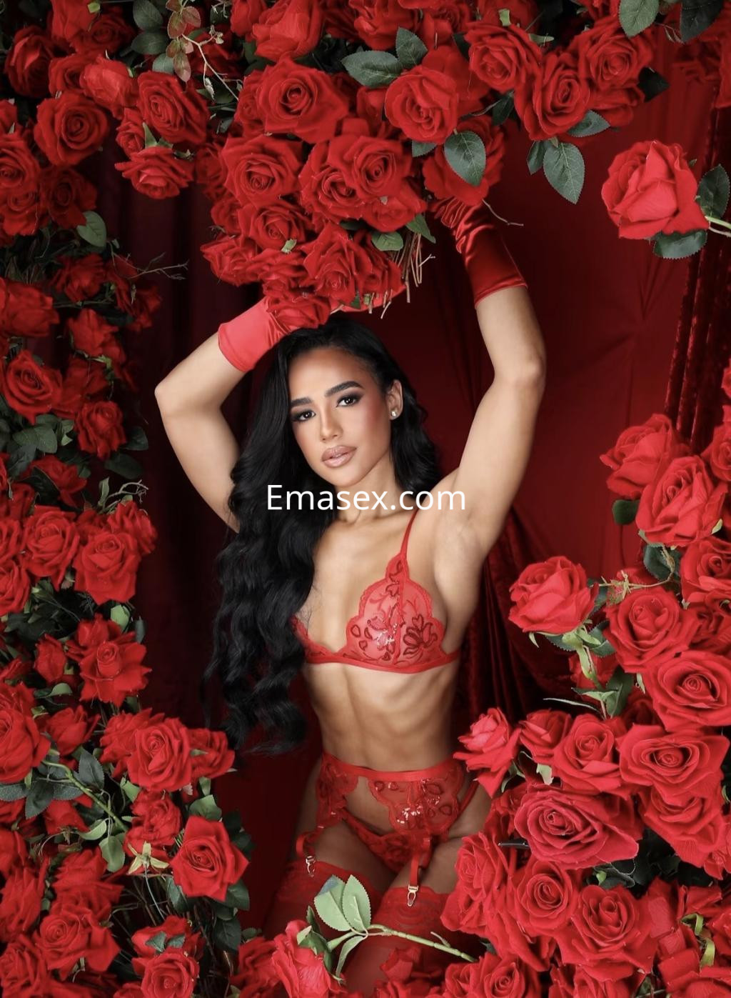 La puta luce un conjunto de lencería roja en medio de un fondo de rosas rojas en Irún.