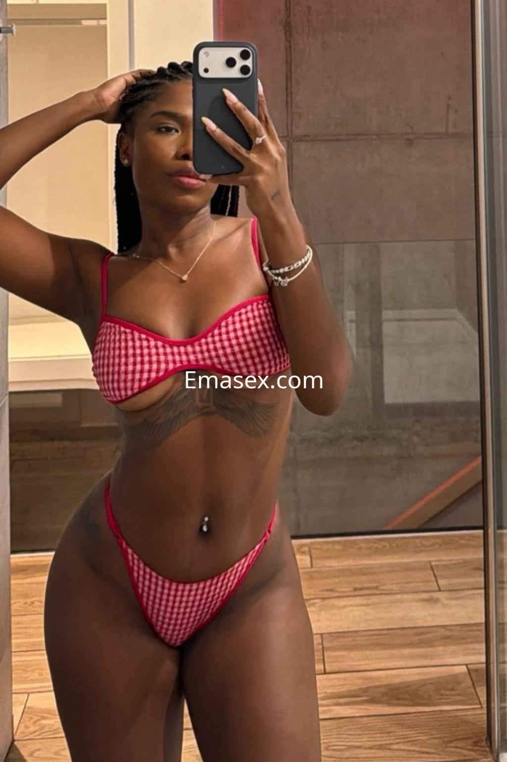 Escort en Gijón se toma una selfie en el espejo, luciendo un bikini de cuadros rojos y una figura estilizada.