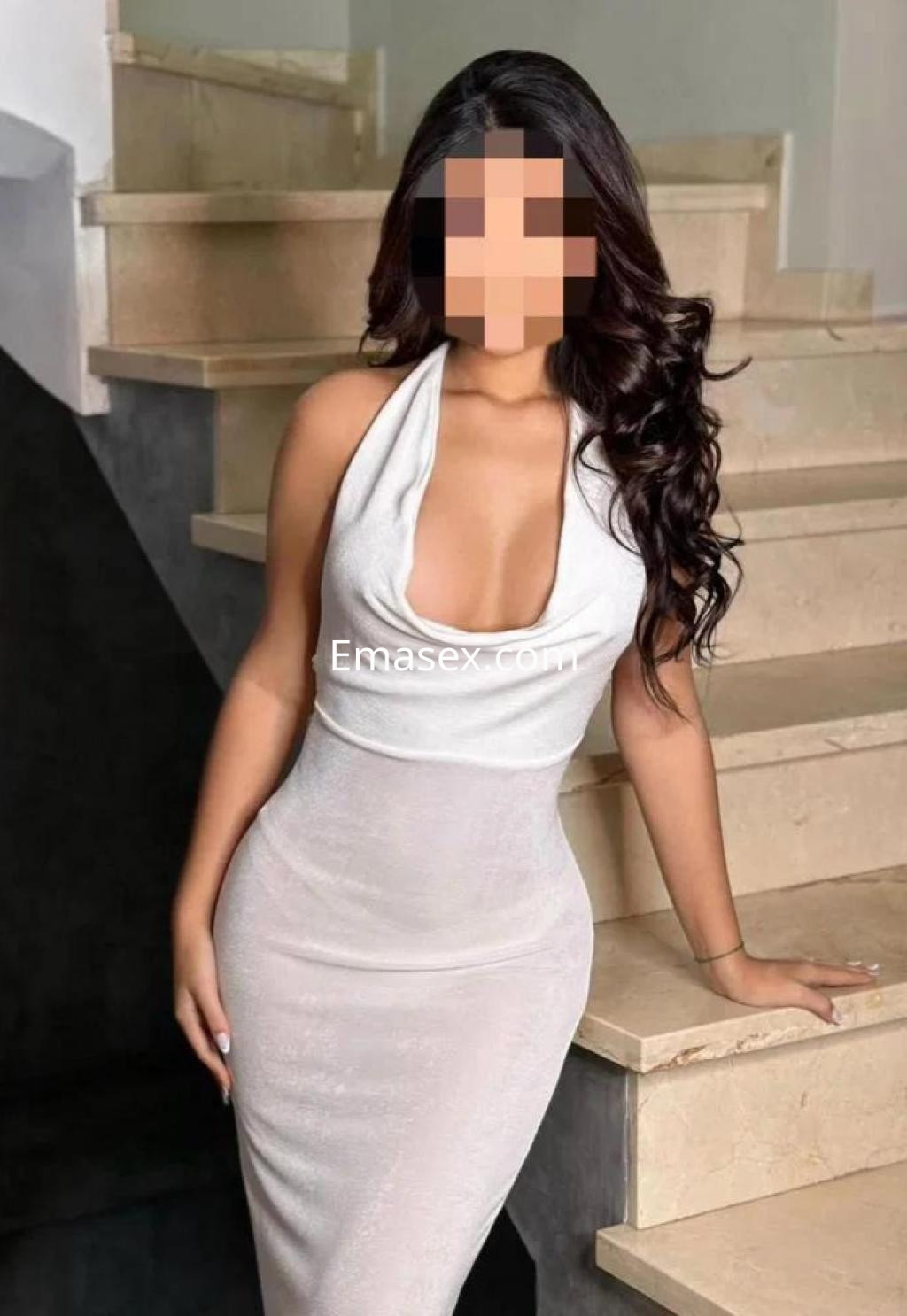 Puta en Las Palmas, vistiendo un vestido blanco ajustado que resalta su figura, posando en una escalera.