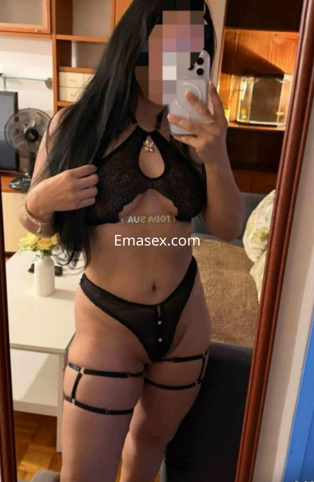Escort en Coruña, posando en un espejo con lencería negra, mostrando una figura curvilínea y elegante.