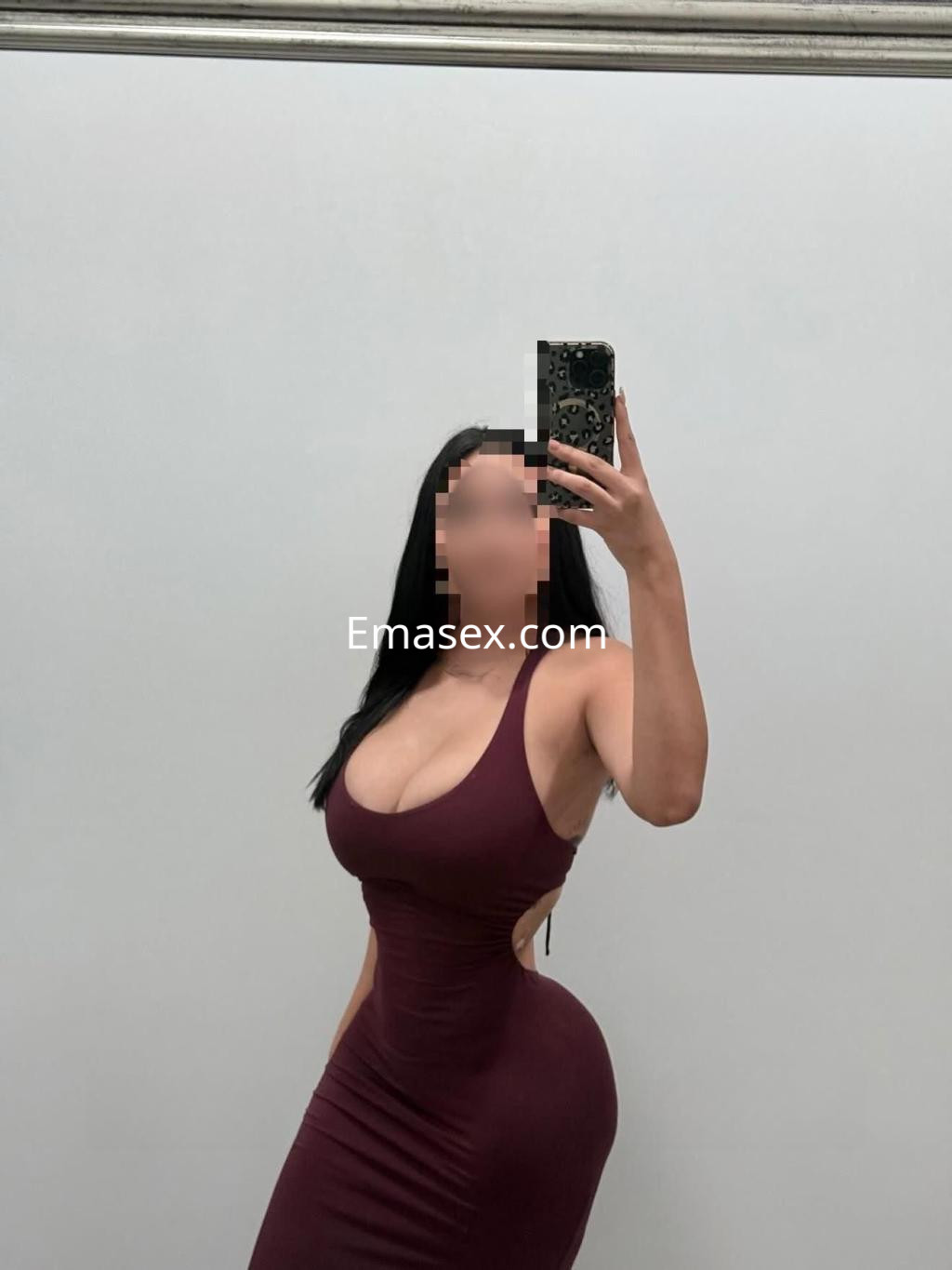 Puta en Córdoba posa con un vestido ajustado color burdeos que resalta su figura y escote.