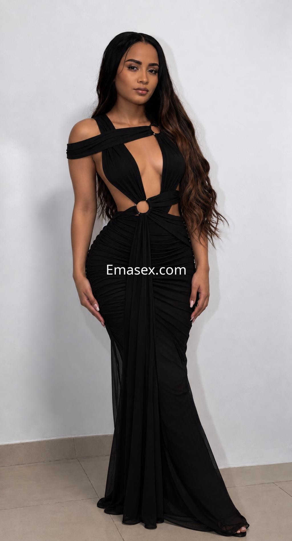 Puta en Oviedo con un vestido negro ajustado y detalles en la cintura, de pie con cabello largo y lacio.