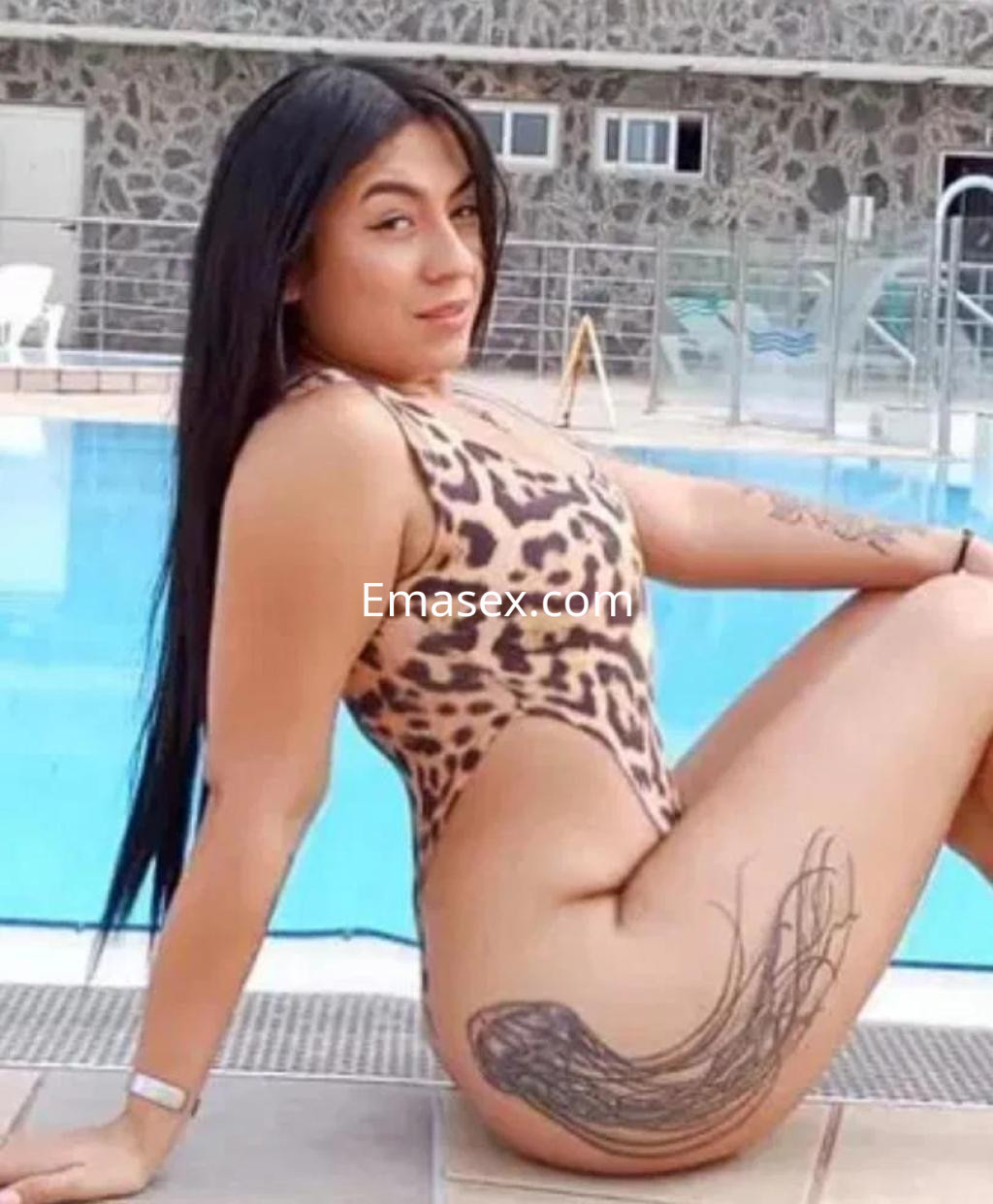 Puta posando de perfil junto a una piscina, con un traje de baño de leopardo y cabello largo y lacio en Las Palmas.