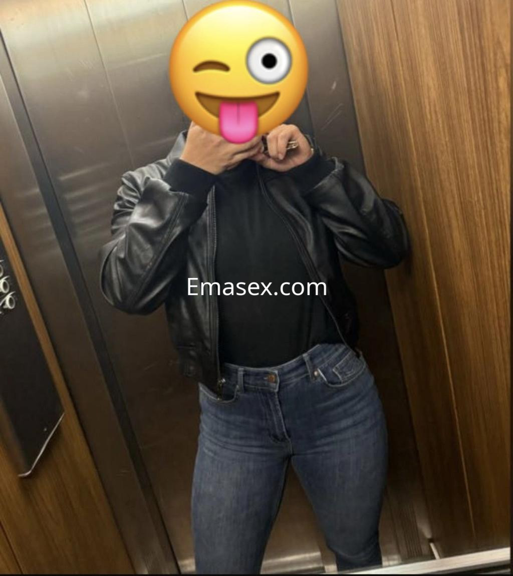 La puta luce una chaqueta de cuero negro y jeans ajustados mientras se toma una selfie en un ascensor en Vigo.