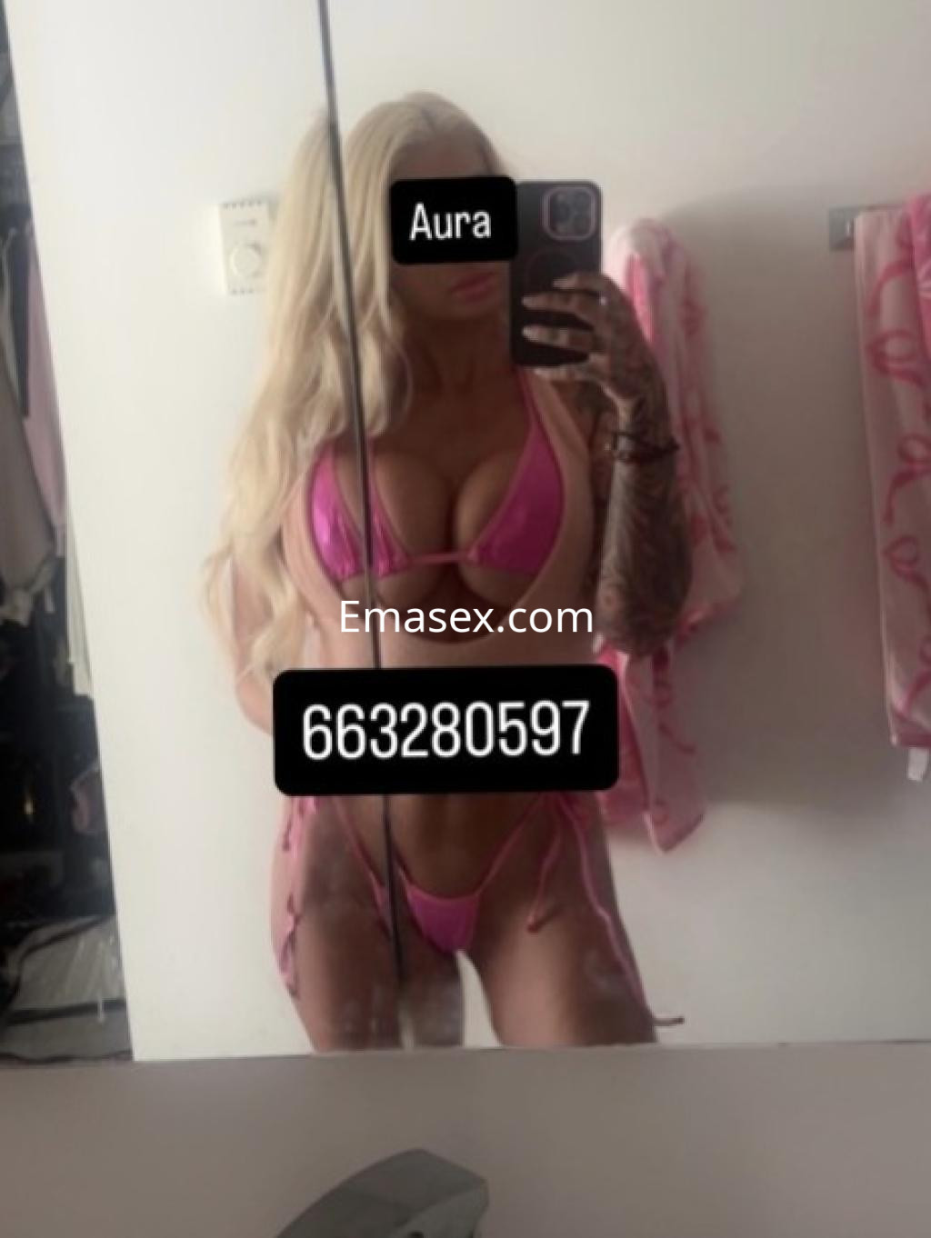 Escort en Castellón con cabello largo y rubio, viste un bikini rosa y se toma una selfie en el espejo.