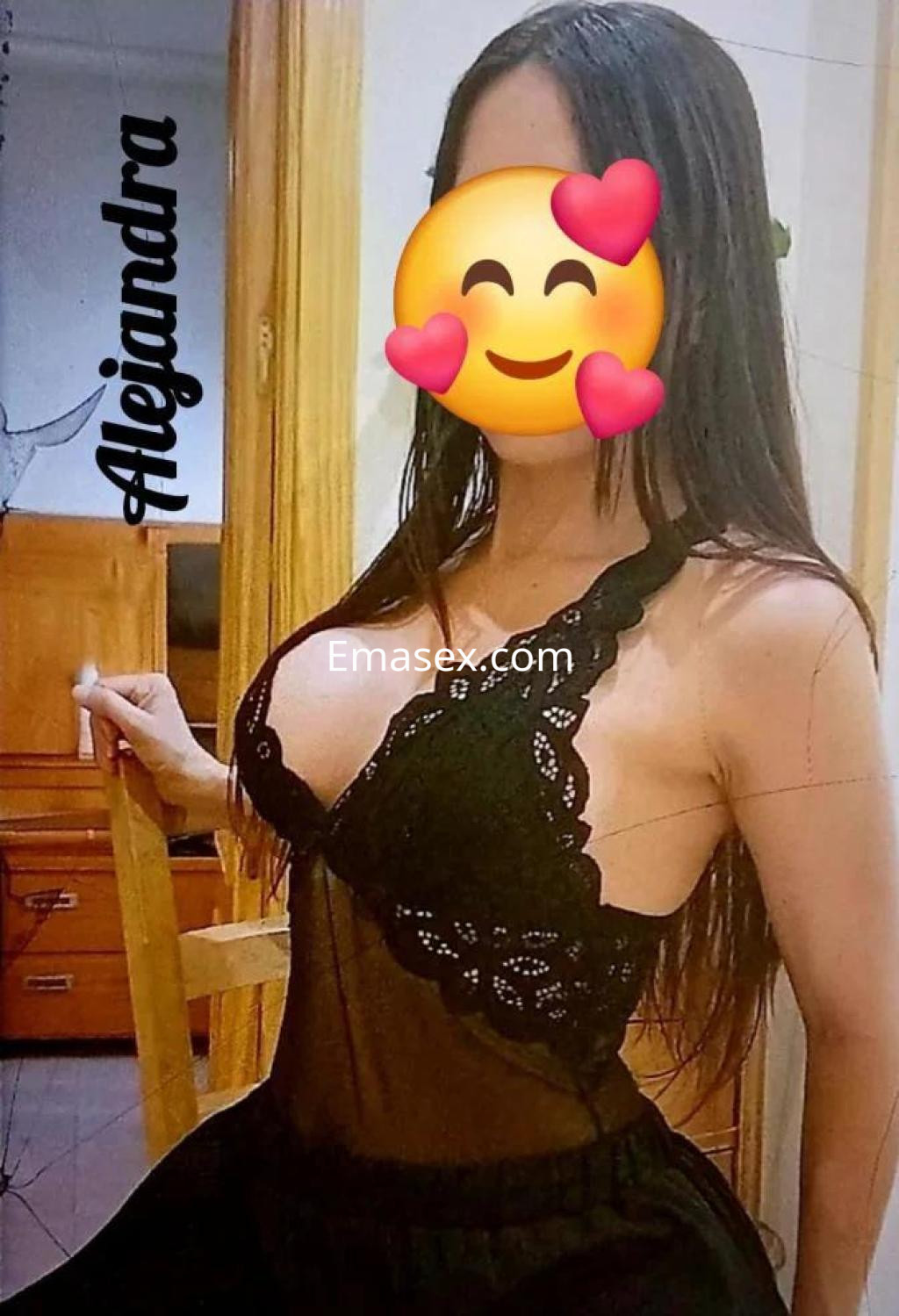 Escort en Toledo posando con un vestido de encaje negro, mostrando una expresión coqueta y un entorno acogedor.