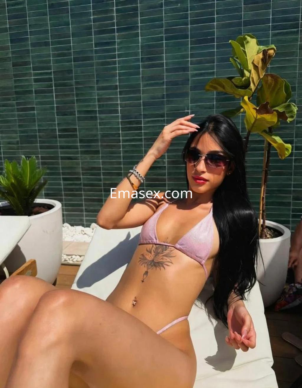 La puta se relaja en una tumbona con un bikini rosa, gafas de sol y un tatuaje visible en el abdomen en Salamanca.