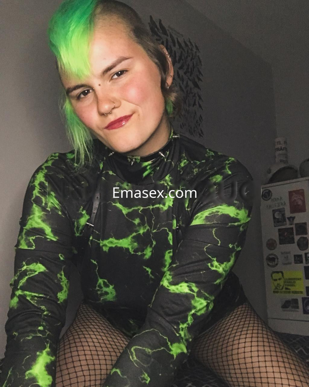 La puta luce un atuendo negro con detalles verdes, con mallas de red y un peinado llamativo en Lleida.