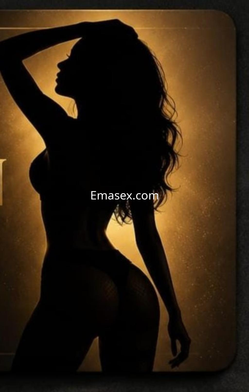 Escort en Almería con silueta marcada, posando de perfil con cabello ondulado y lencería negra en un fondo iluminado.
