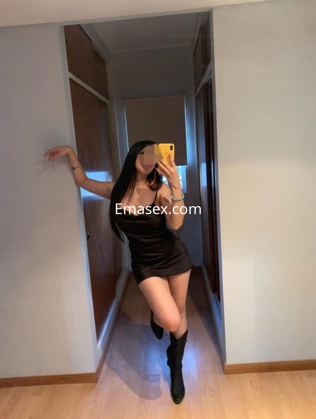 Puta posando en un vestido negro ajustado y botas altas, en un ambiente interior de Bilbao.