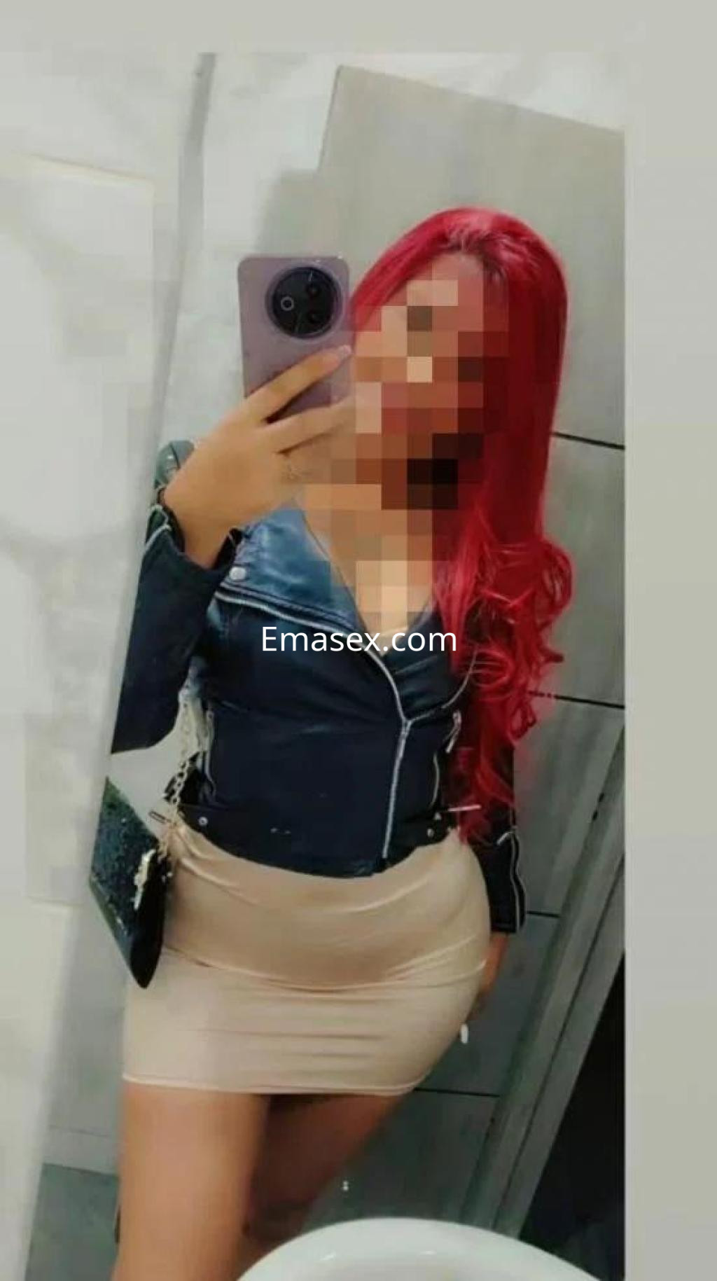 Puta con cabello largo y rojo, viste una chaqueta de cuero negra y una falda corta color nude en Toledo.