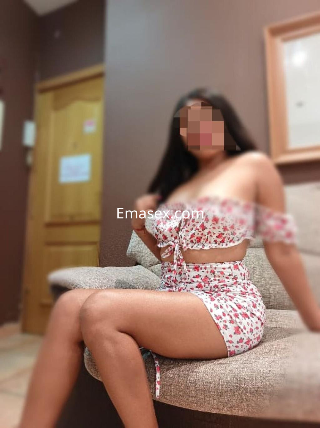 La puta viste un conjunto floral de dos piezas mientras se sienta en un sofá en Toledo.