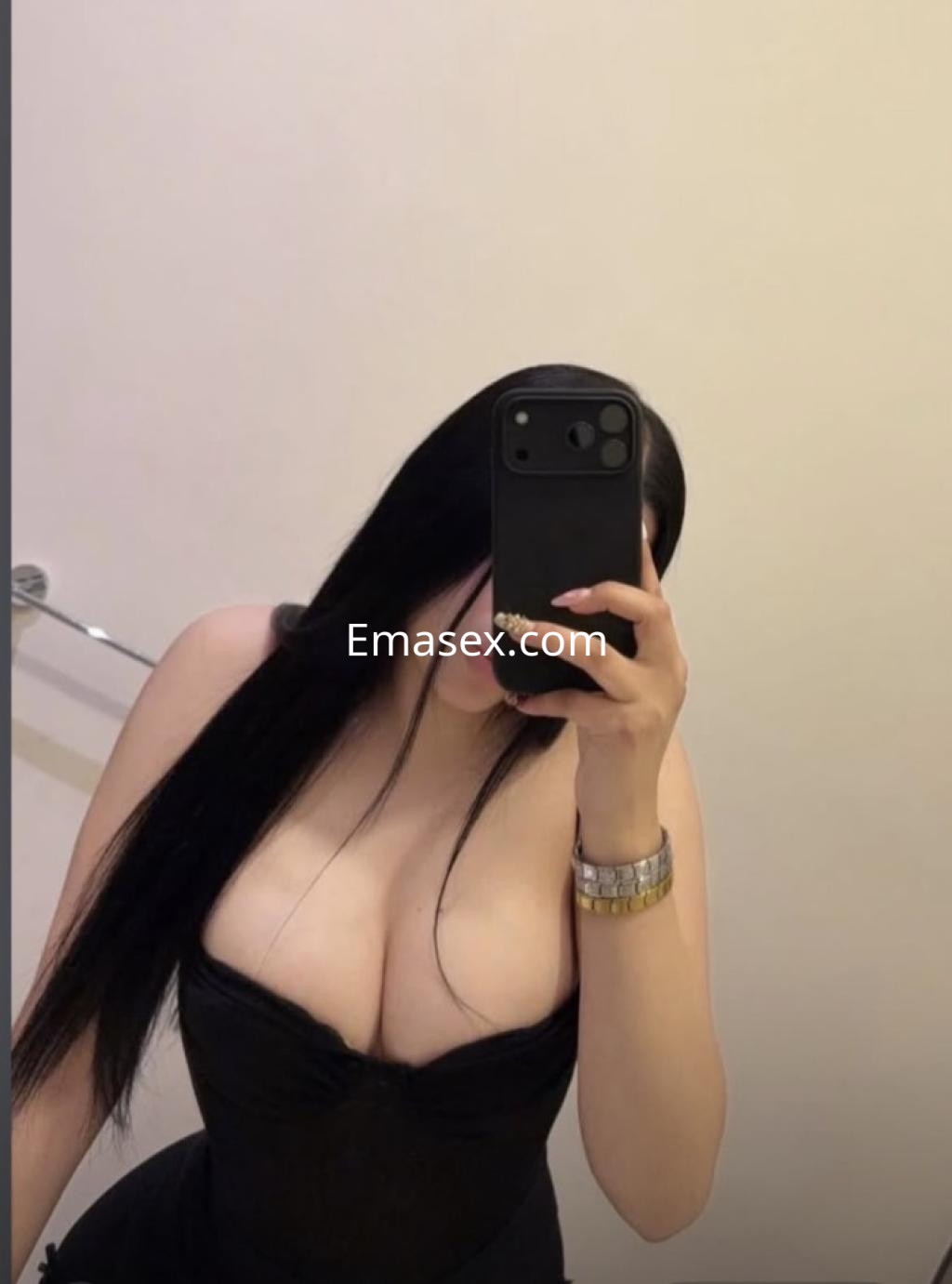 Escort en Lugo con cabello largo y lacio, viste un corsé negro que resalta su figura, posando frente al espejo.