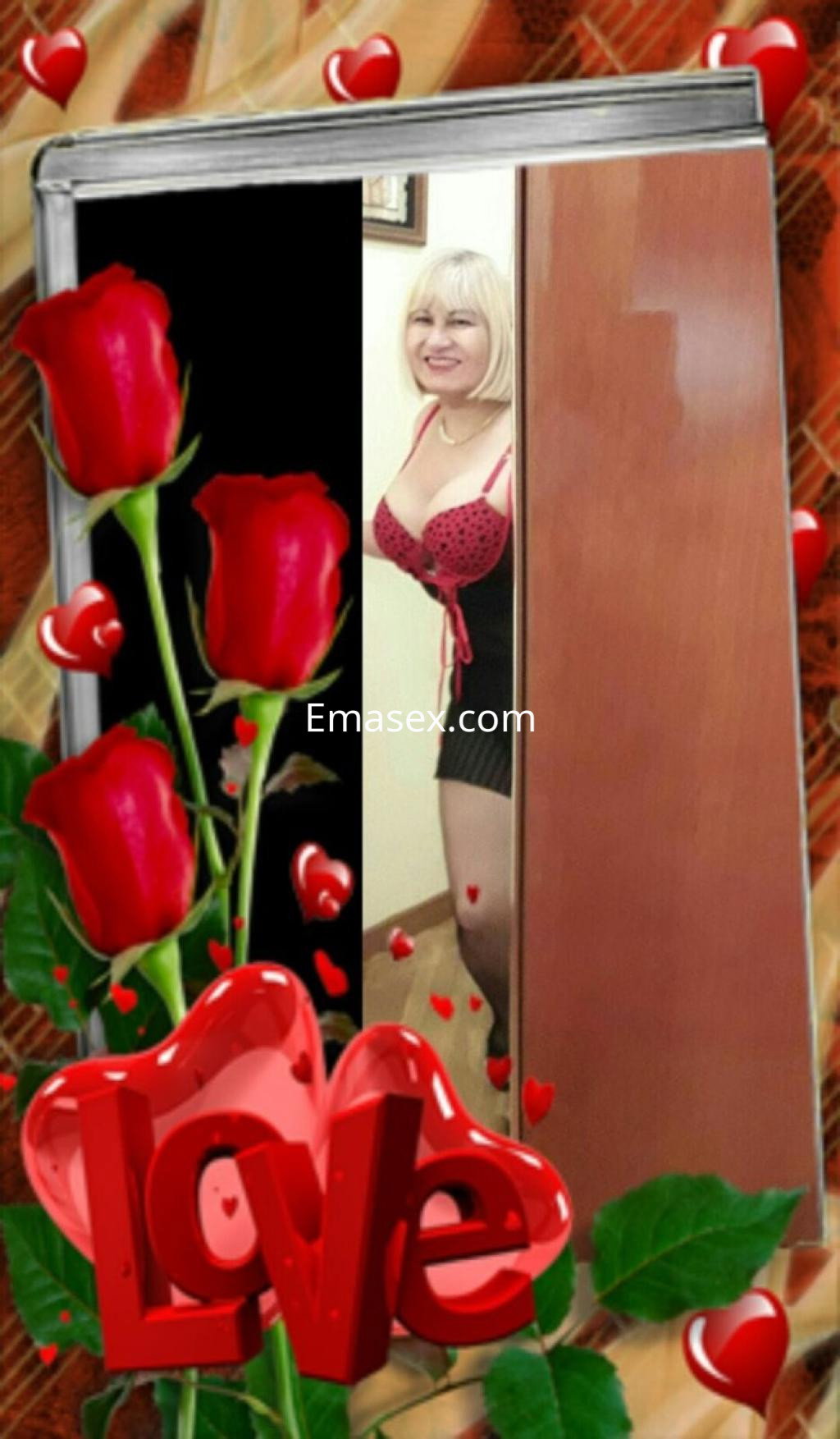 La puta en León viste lencería negra con detalles rojos y sonríe mientras se asoma detrás de una puerta.