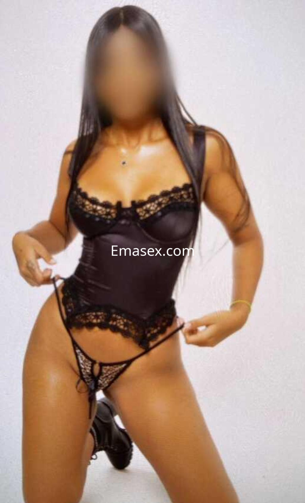 Escort en Málaga posando con lencería negra ajustada y detalles en encaje, mostrando una actitud coqueta.