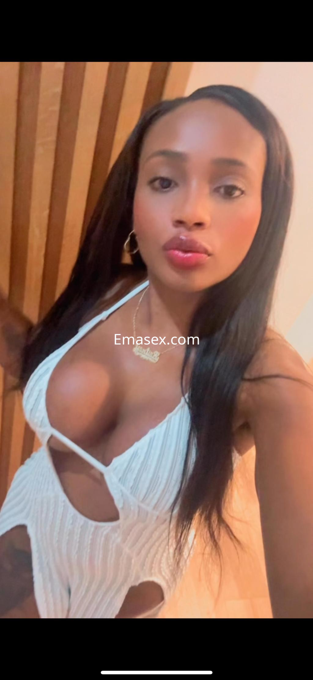 Puta en Granada viste un conjunto blanco con cortes, mostrando su figura y cabello largo y lacio.