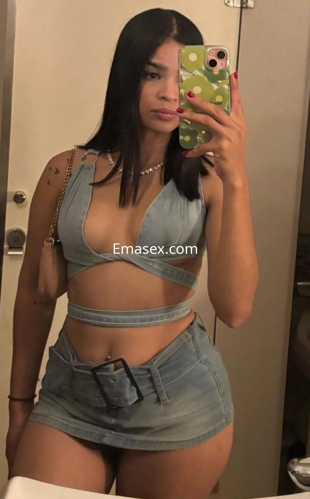 Escort en Coruña luciendo un conjunto de denim que incluye un top de tirantes y una minifalda ajustada, posando con confianza.
