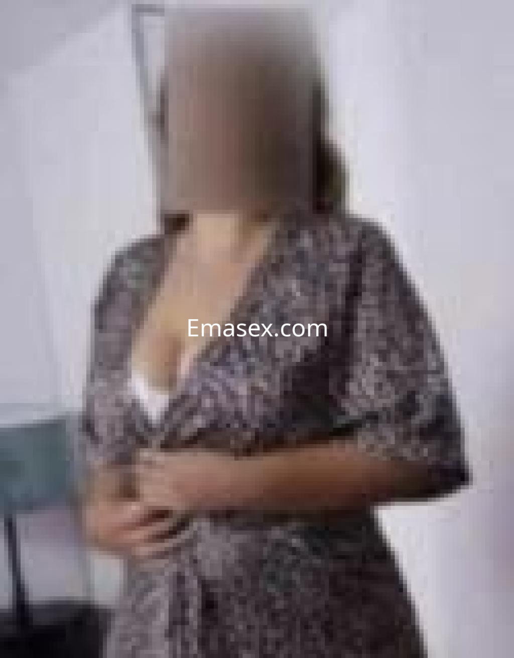 Puta en Cáceres con un vestido estampado, mostrando una blusa blanca en un entorno minimalista.