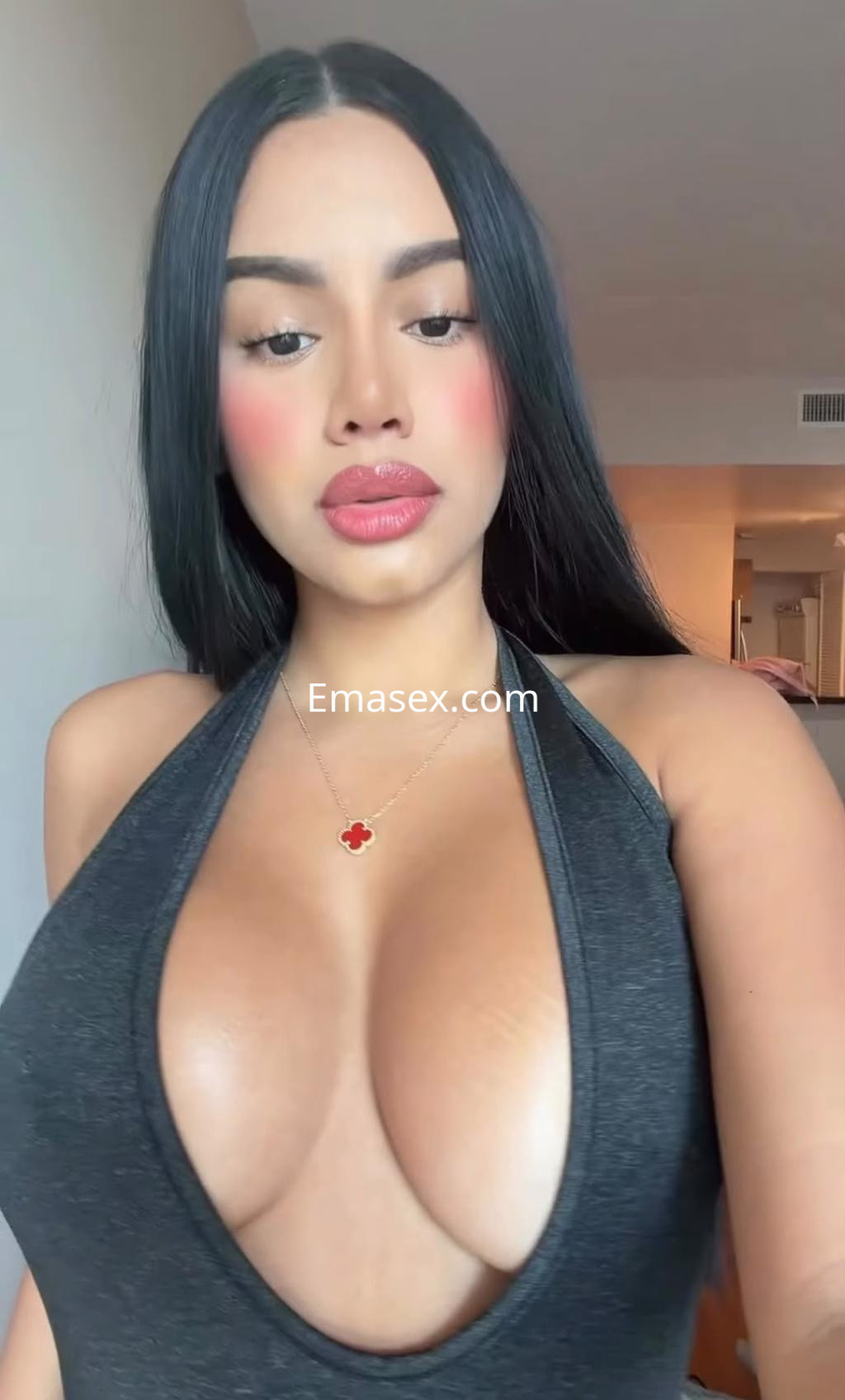 Escort en Bilbao con cabello largo y lacio, luciendo un vestido negro de escote profundo y maquillaje suave.