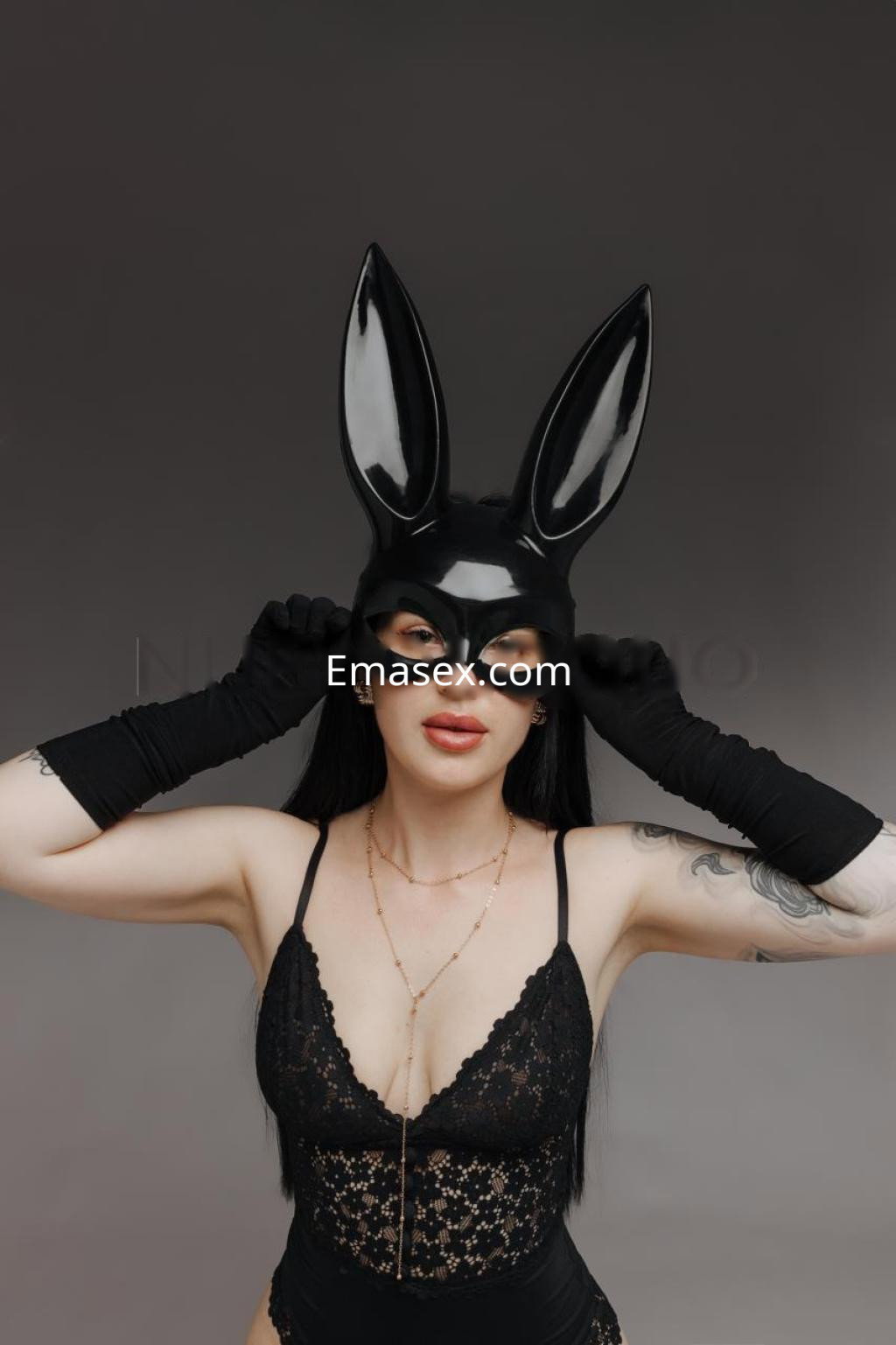 La escort en Tarragona lleva un atuendo negro con encaje y un máscara de conejo, mostrando un estilo audaz y elegante.