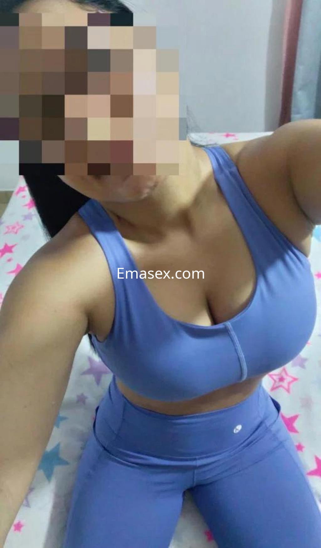 Escort en Oviedo posa en un entorno interior con ropa deportiva de color azul claro, mostrando su figura.