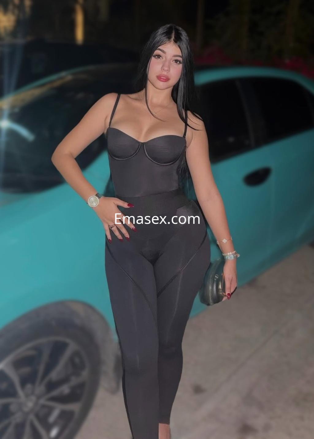 Puta en Valladolid con cabello largo y lacio, vistiendo un body negro y leggings ajustados, posando junto a un coche.
