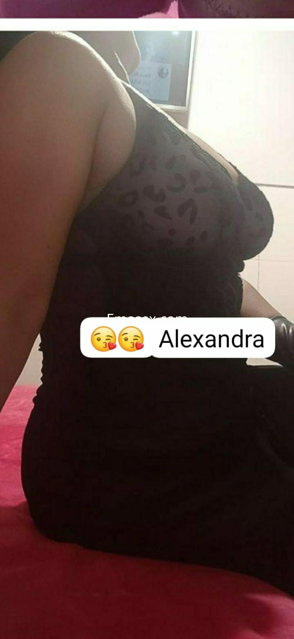 Escort en Donosti posando de lado con un vestido negro ajustado y detalles de encaje, mostrando una silueta elegante.