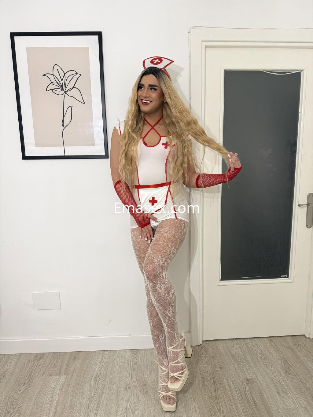 Escort trans en Logroño con un disfraz de enfermera, cabello largo y rubio, y medias transparentes.