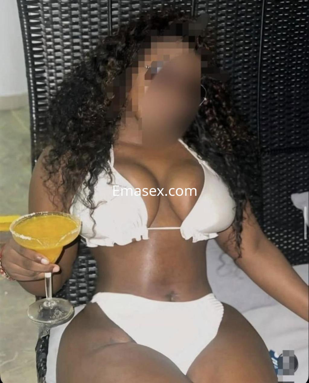 Puta posando en Barcelona con bikini blanco, sosteniendo una copa, en un ambiente relajado y luminoso.