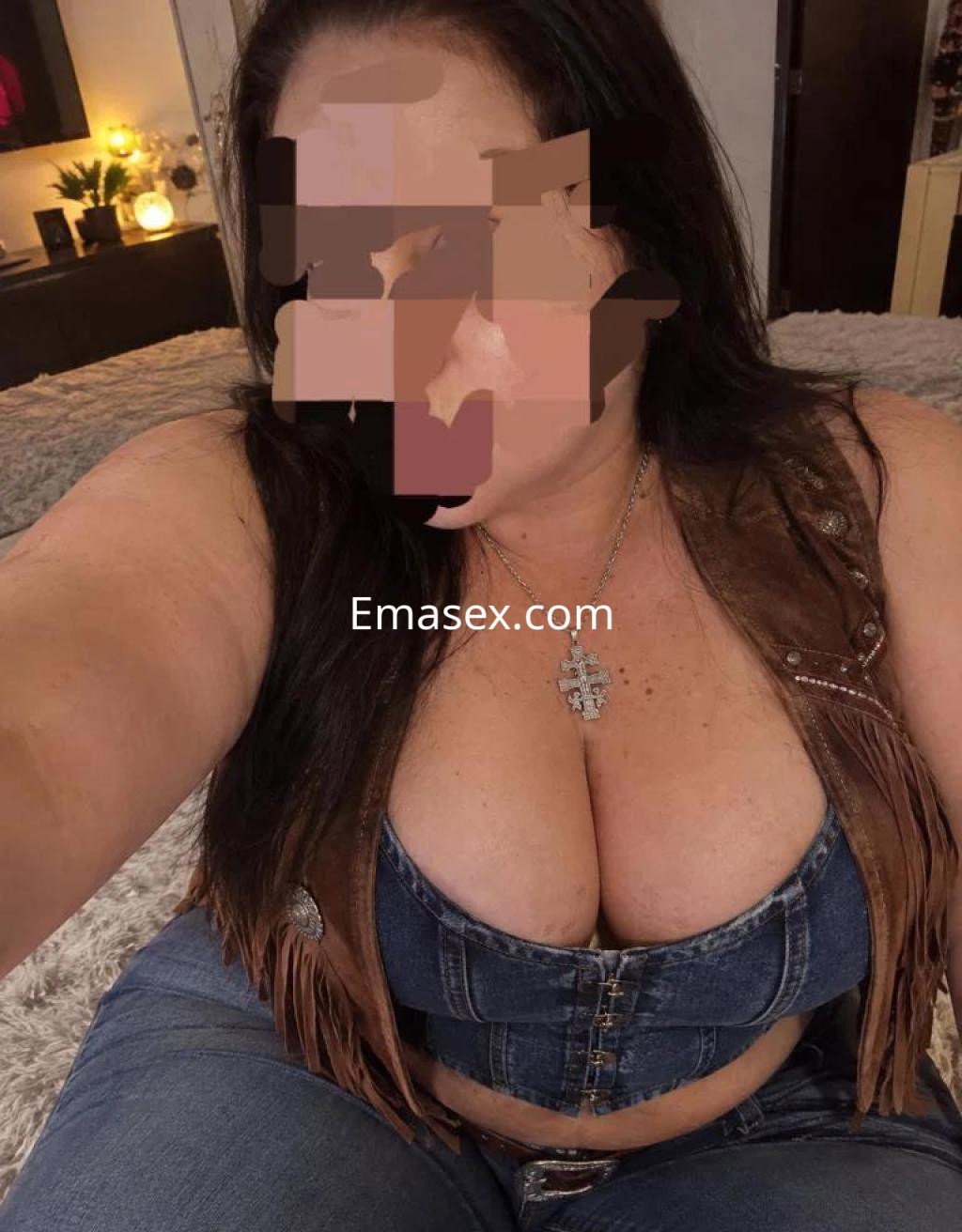 Puta en Sevilla, con blusa de mezclilla ajustada y jeans, posando en un ambiente acogedor y elegante.