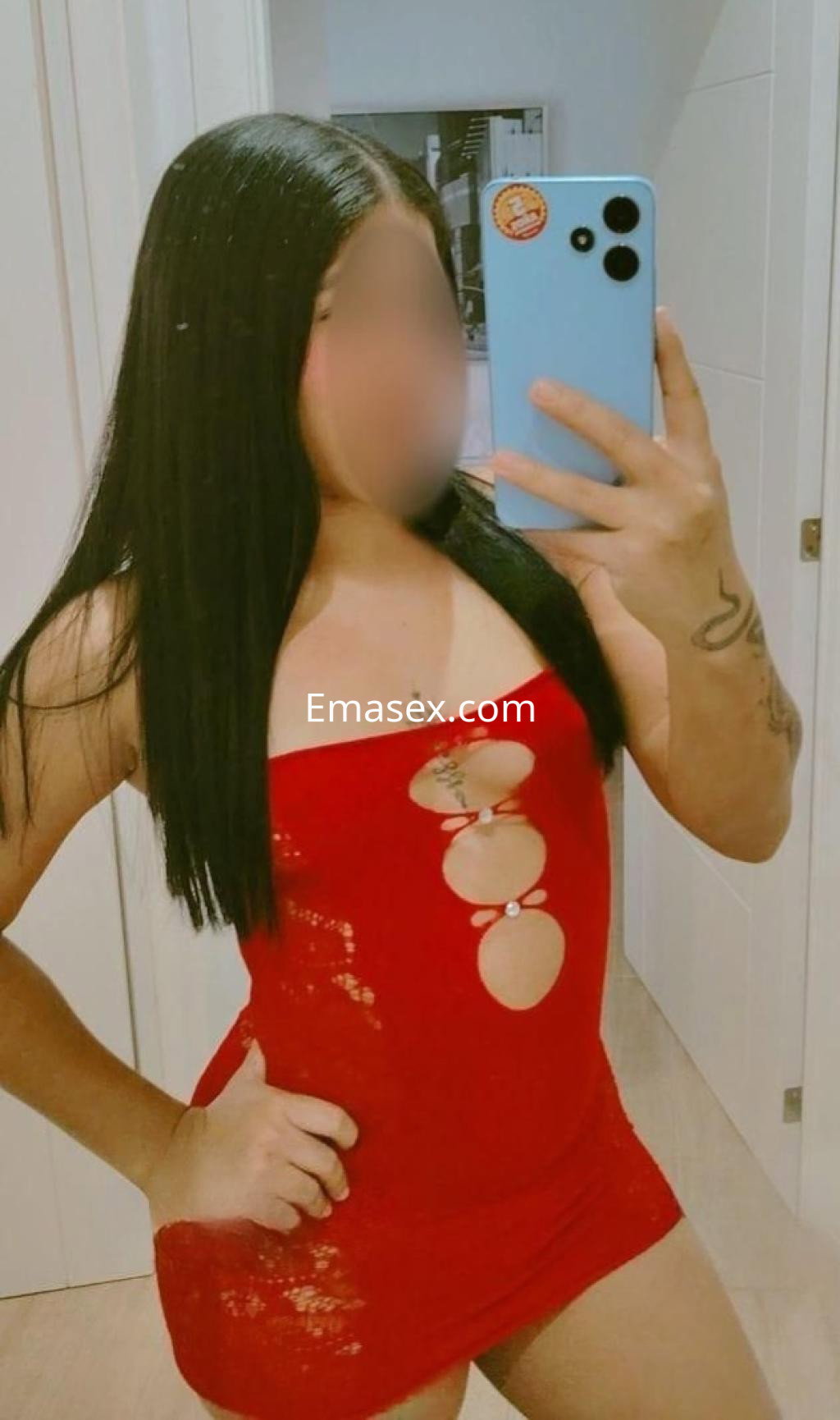 Escort en Granada, luciendo un vestido rojo ajustado con detalles en el escote y cabello largo y lacio.